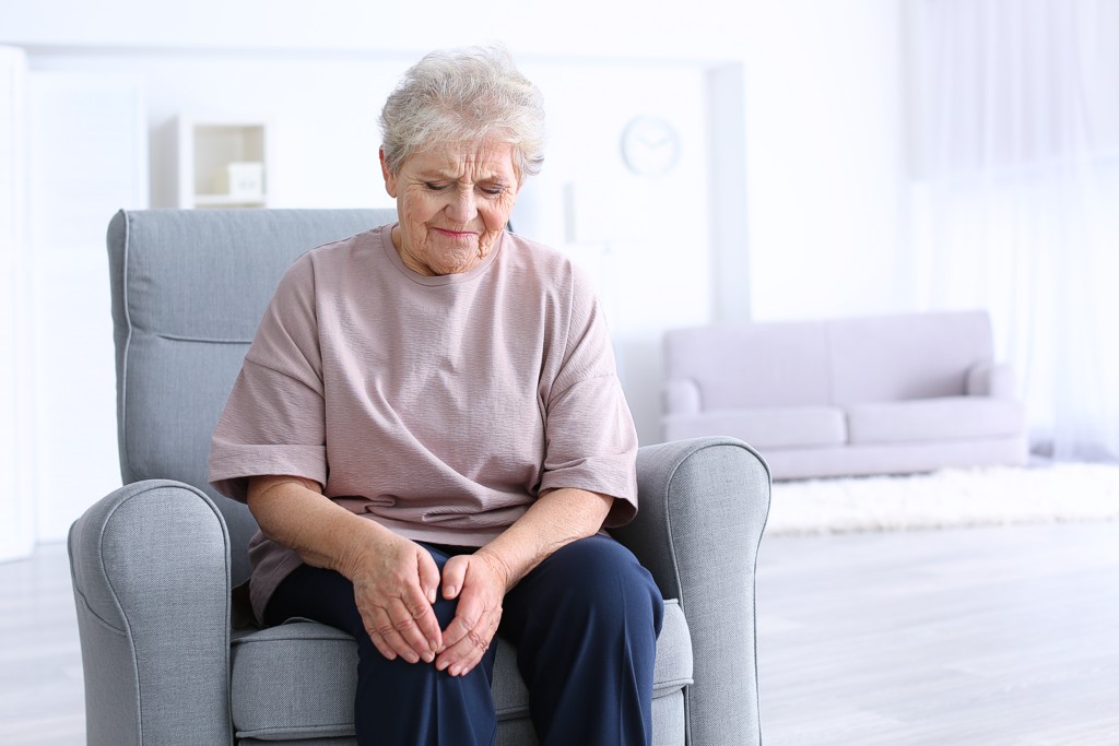 Ältere Frau leidet an Knieschmerzen