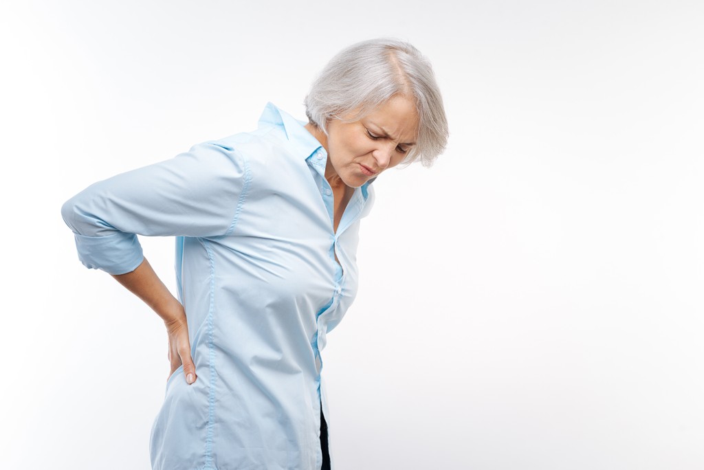 Osteoporose Symptome Ältere Frau hat starke Rückenschmerzen
