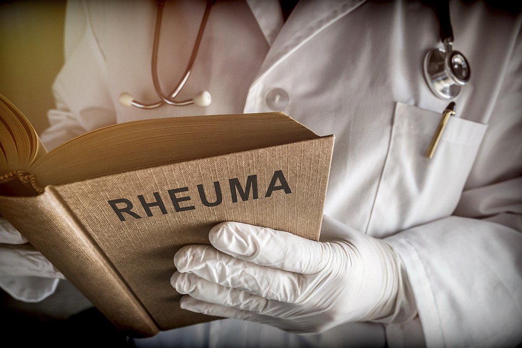 Ein Arzt hält in seinen Händen ein altes Buch über Rheuma