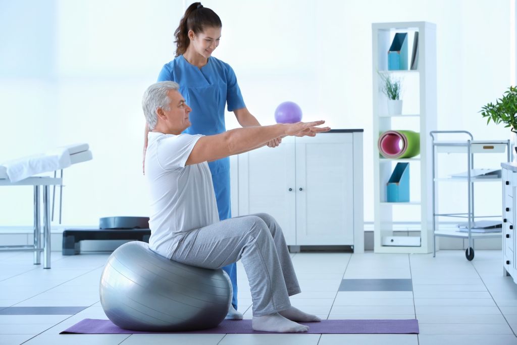 Physiotherapeutin bei der Arbeit mit dem Patienten in der Klinik