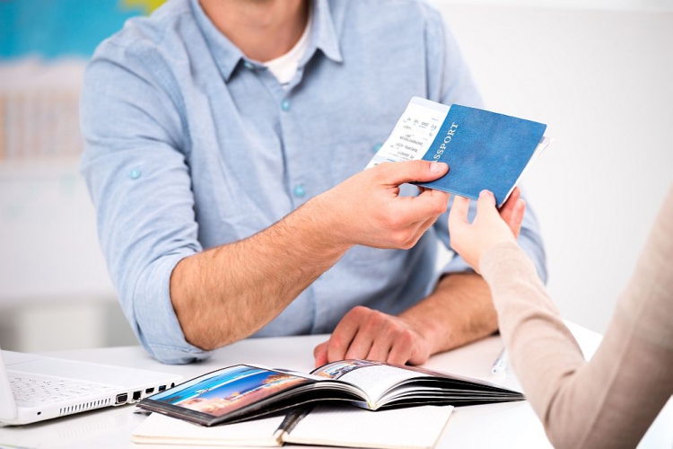 Eine Frau bekommt von einem Reisemakler Ihren Reisepass mit Tickets zurück